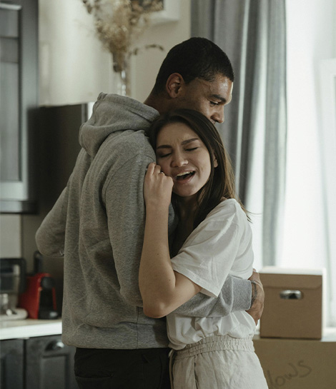 Woman huffing her partner in their new home, represents how anxiety therapy helps you move forward.