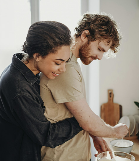 Woman hugging his partner while he washes the dishes, represents how ADHD spouse support can help couples work together and feel closer.