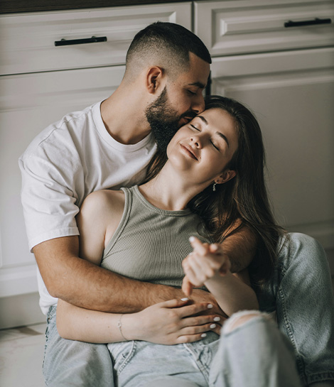 Couple sitting on the kitchen floor holding each other represents how you can rebuild trust and connection through infidelity counseling.