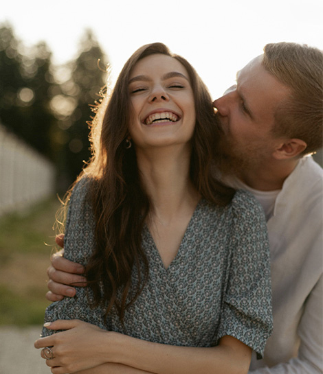 Man hugging his wife while she's laughing, represents how you reignite your passion and connection through intimacy counseling in Orange County.
