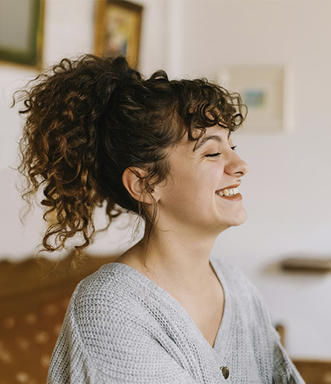 Woman laughing on her own, represents how working with an individual therapist can help you focus on yourself and your needs.