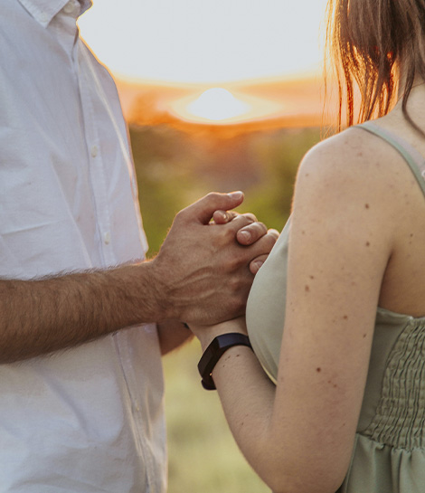 Couple holding hands at sunset, represents how working with a discernment counselor in Newport Beach can help couples gain clarity and make a decision together.