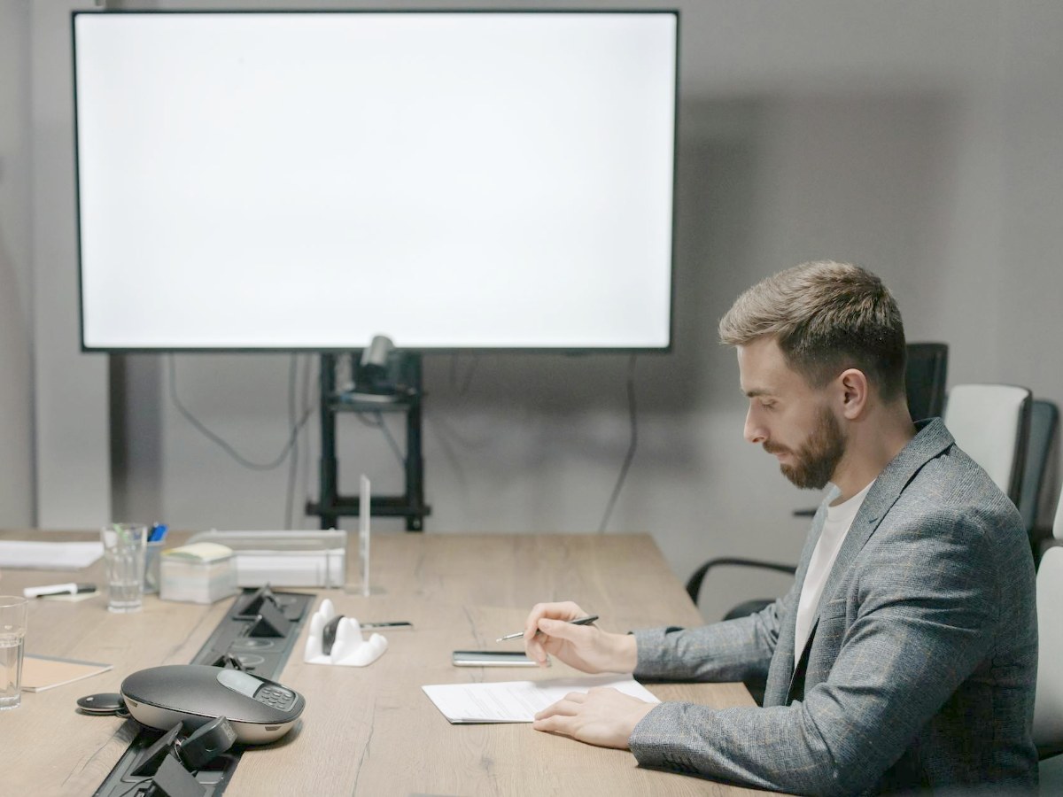 Professional sitting quietly before a meeting, appearing thoughtful and tense
