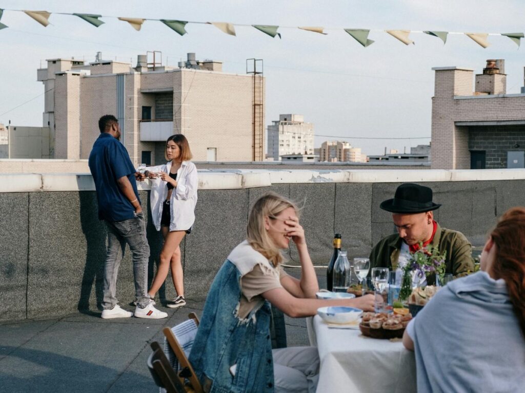 Woman at social gathering with hands over her eyes as she replays a conversation in her head