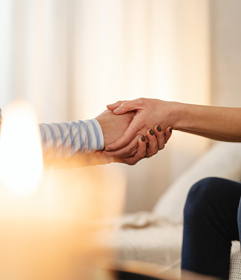 Comforting handshake surrounded by candles, represents how a Christian therapist can support you in your journey.
