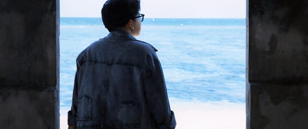 Anonymous person looking out at the ocean while reflecting on guilt after cheating.