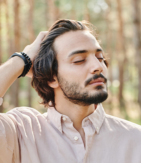 Man having a calm moment in nature, represents how CBT therapy can help you pause and respond rather than react.